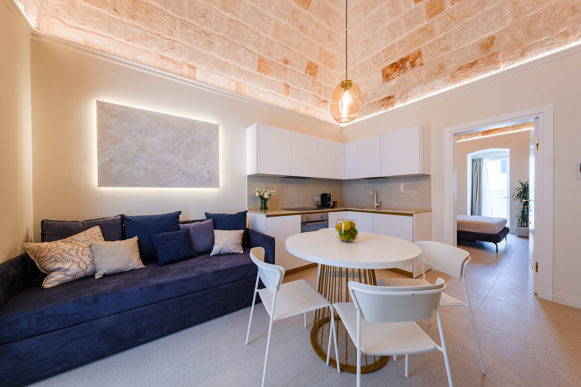 Soggiorno con divano blu e cucina