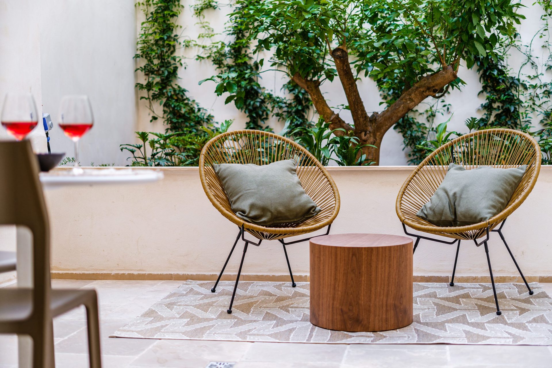 Due poltrone e un tavolino fra il verde della terrazza